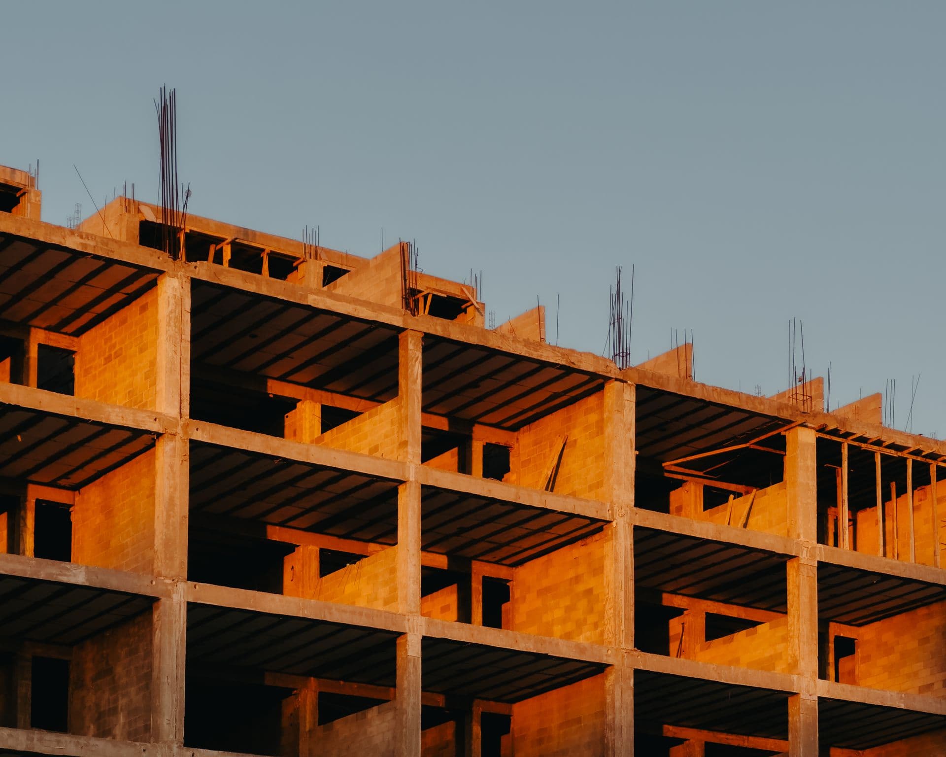 Partially built residential building, exposed concrete structure against an evening sky
